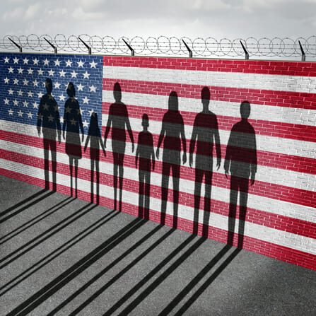 American immigration and United States refugee crisis concept as people on a border wall with a US flag as a social issue about refugees or illegal immigrants with the cast shadow of a group of migrating women men and children.